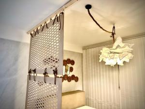 uma casa de banho com uma cortina de chuveiro e um lustre em Apartment B&B em Vogošća