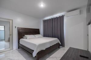 ein Schlafzimmer mit einem Bett in einem Zimmer mit einem Fenster in der Unterkunft Ramey Cir D, near airport, beaches W/KING Bed. in Aguadilla