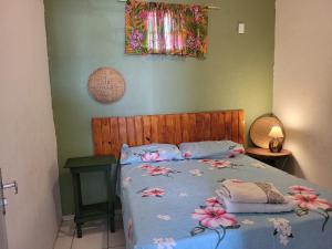 - un lit avec une couette bleue et des fleurs dans l'établissement Namoasuites, à Maceió