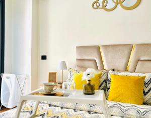 a living room with a bed with yellow pillows at Rafina A12 in Casablanca