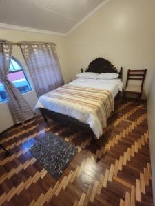um quarto com uma cama grande e uma janela em Hermoso Departamento Central Familiar Tu Refugio con Impresionantes Vistas a la Ciudad, Montañas y Nevados em Riobamba
