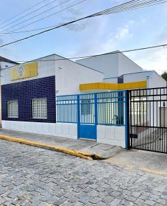 a blue and white building with a gate on a street at HOSTEL CAMINHO DA FE in Aparecida