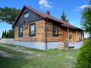 a small wooden house with a red roof at Dom Na Wsi in Mierzwin Duży