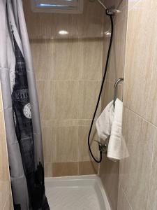 y baño con ducha y reloj. en Hostal Las Vegas, en Madrid