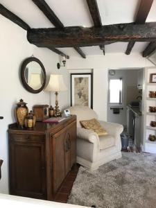 una stanza con tavolo, sedia e specchio di Pipers Cottage - Quirky Cottage near Ironbridge! a Broseley