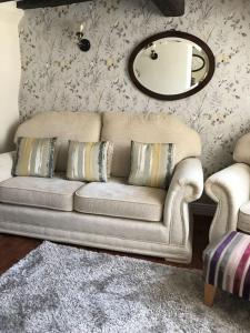 a living room with a couch and a mirror at Pipers Cottage - Quirky Cottage near Ironbridge! in Broseley