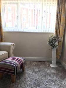 a living room with a chair and a window at Pipers Cottage - Quirky Cottage near Ironbridge! in Broseley