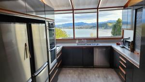 a kitchen with a sink and a large window at The Black Chalet in Whitianga