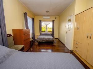 ein Schlafzimmer mit einem Bett, einer Kommode und einem Fenster in der Unterkunft Prime location Apartment in Paramaribo in Paramaribo