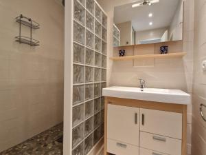 a bathroom with a sink and a glass block wall at Bel appartement T2 avec balcon, WIFI et parking près de la plage - FR-1-706-2 in Châtelaillon-Plage +13 photos