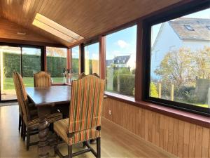 a dining room with a table and chairs and windows at Maison avec Jardin, WIFI, proche plage et commerces, calme - Perros-Guirec - FR-1-368-374 in Perros-Guirec
