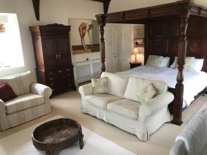 ein Schlafzimmer mit einem Bett, einem Sofa und einem Tisch in der Unterkunft Worthy Manor in Culbone