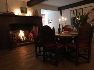 Worthy Manor في Culbone: غرفة طعام مع طاولة ومدفأة