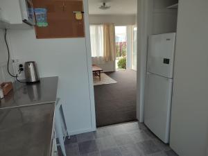 a kitchen with a white refrigerator and a hallway at Nesting In Hamilton East in Hamilton