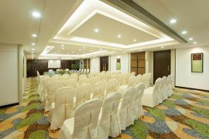 una sala de banquetes con sillas blancas en una habitación en Emperor Hotel, en Macau