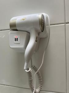 a white hair dryer hanging on a wall at Recanto da Ivete in São Sebastião