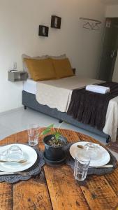 uma mesa com pratos e copos em cima de uma cama em Suite Sol - Residencial Vivas em Praia do Forte
