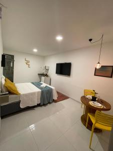 una camera con letto, tavolo e TV di Suite Sol - Residencial Vivas a Praia do Forte