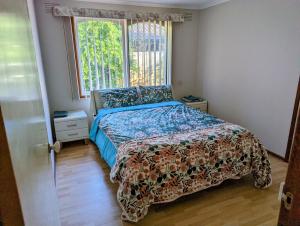 a bedroom with a bed with a comforter and a window at Corporate Share House in Melbourne