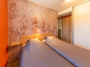 a bedroom with a bed against a wall at Splendid home near the Spa Francorchamps circuit in Stavelot