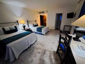 um quarto de hotel com duas camas e um piano em Ritz Acapulco All Inclusive em Acapulco