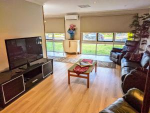 ein Wohnzimmer mit einem großen Flachbild-TV und Sofas in der Unterkunft Corporate Share House in Melbourne