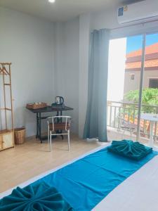 a bedroom with a bed with blue sheets and a balcony at Guest house Helene in Kata Beach