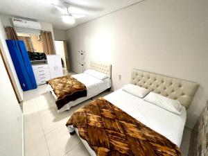 a hotel room with two beds and a kitchen at Recanto da Ivete in São Sebastião