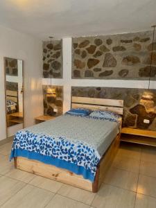 a bedroom with a bed and a stone wall at La Tablita in Zorritos