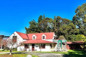 a white house with a red roof and trees at The Loft @ Gladstone Vineyard in Gladstone