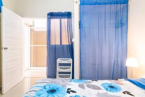 - une chambre avec un lit doté de rideaux bleus et d'une fenêtre dans l'établissement Habitación cerca al Mar, Obelisco Hembra y Zona Colonial, à Saint-Domingue