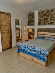 a bedroom with a bed with a blue and white comforter at La Tablita in Zorritos