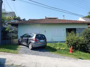 Ein kleiner Wagen parkte vor einem Haus in der Unterkunft Viva a vida com amor e amigos in Blumenau