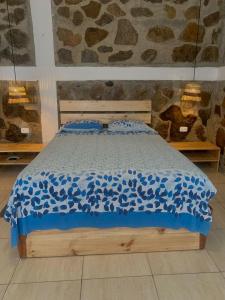 a bed with a blue comforter in a bedroom at La Tablita in Zorritos