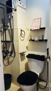 W łazience znajduje się prysznic oraz toaleta z czarnym dywanem. w obiekcie Casa Cabilao Staycation w mieście Santa Rosa