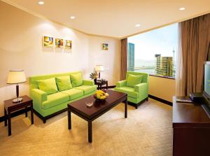 a living room with green furniture and a large window at Emperor Hotel in Macau