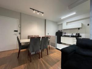 uma sala de estar com mesa e cadeiras e uma cozinha em Bexp Spaces | Mackenzie Alphaville em Aldeia
