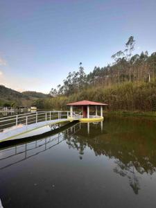 a dock with a gazebo in the middle of a lake at Lindo sítio para você e sua família! in Guararema