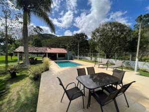 瓜拉雷馬的住宿－Lindo sítio para você e sua família!，一个带桌椅的庭院和一个游泳池