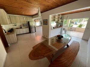 een grote keuken met een houten tafel in een kamer bij Lindo sítio para você e sua família! in Guararema