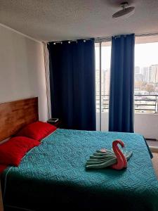 a bedroom with a bed with a swan on it at Lindo Departamento Amoblado (Cercano a terminal Sur y Aeropuerto) in Santiago