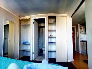 a room with white closets and a bedroom at Departamento equipado (Cercano a terminal Sur y aeropuerto) in Santiago