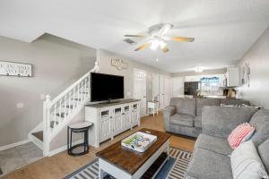 a living room with a couch and a flat screen tv at Barefoot Bungalow in Panama City Beach