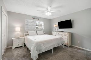 a bedroom with a bed and a flat screen tv at Barefoot Bungalow in Panama City Beach