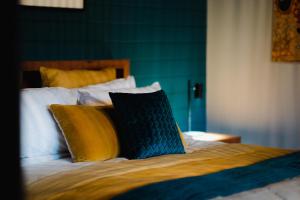 a bed with yellow and blue pillows on it at Eliza's in Bright