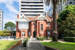 a red brick house with a palm tree in a city at 'The Albert' Where the City meets St Kilda in Melbourne