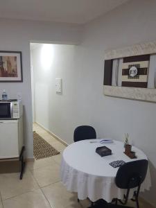 a room with a white table with chairs and a microwave at Studio 501 Campinas SP in Campinas