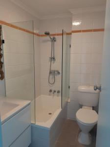 a bathroom with a shower and a toilet and a sink at Little Coogee Hotel in Sydney +52 photos
