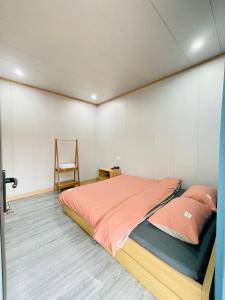 una camera con un letto e una sedia di Homestay Hoa ban a Mộc Châu