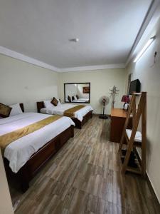 ハノイにあるPhương Thảo Hotelのベッド2台とデスクが備わるホテルルームです。